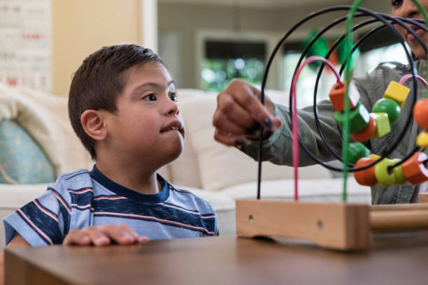 istock Intense focus on face of boy as therapist teaches game 1165345284