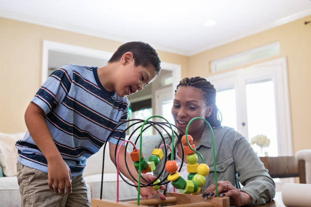 istock Special needs boy tries new toy with therapist 1165345327