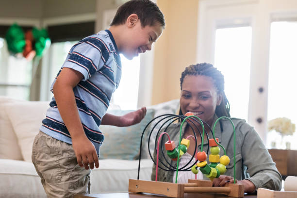 istock Mid adult therapist engages special needs boy in play 1165345443