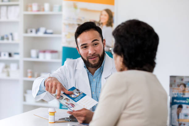 istock Pharmacist shows pamphlet to customer 1165346024