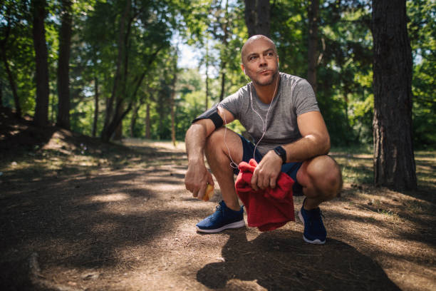 istock Senior retired athlete crouching and eating an apple after a workout 1165346200