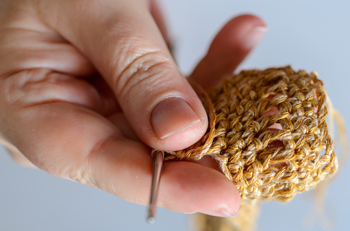 Womans hands with crochet hook and yarn. Handmade hobby concept