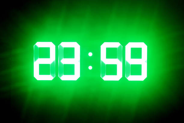 green glowing digits in the dark show 23:59. time is one minute to midnight. - 2359 imagens e fotografias de stock