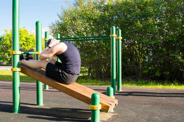 istock a man goes in for sports outdoors, on a special platform, does an exercise on a press 1165349627