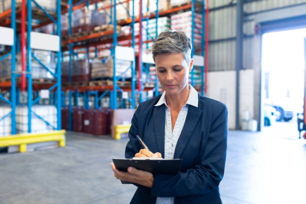 istock Female manager writing on clipboard in warehouse 1165352759