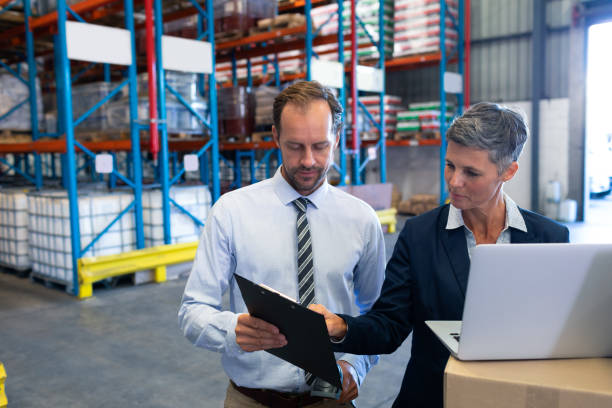 istock Staffs working together on laptop in warehouse 1165355098