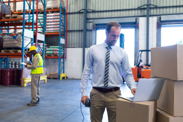 istock Male supervisor working on laptop in warehouse 1165357188