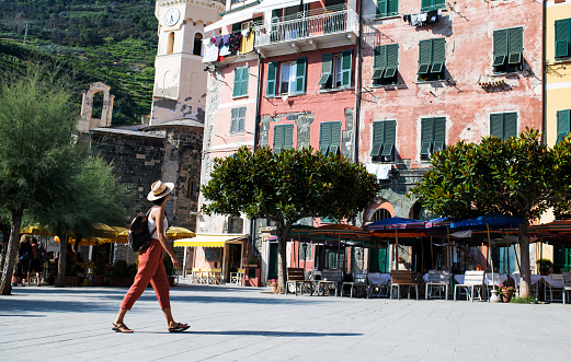 Latin woman walking trough the main square in Vernazza village, Cinque Terre