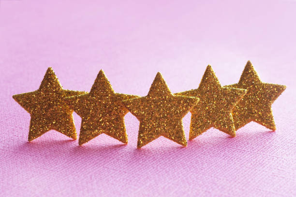 istock five golden stars on a pink background. concept top quality. copy space. 1165361110