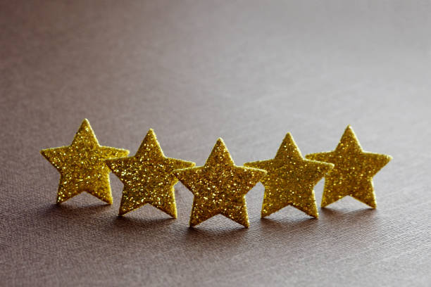 istock five golden stars on a brown background. concept top quality. copy space. 1165361117
