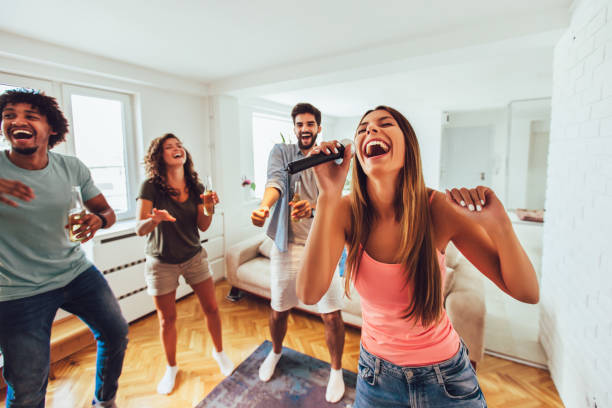 istock Group of friends playing karaoke at home 1165361303
