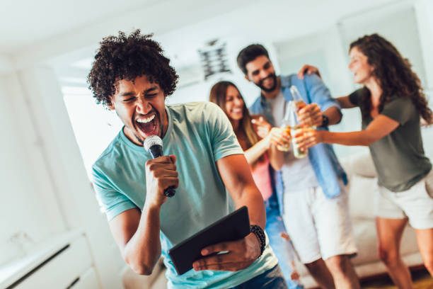 istock Group of friends playing karaoke at home 1165363698