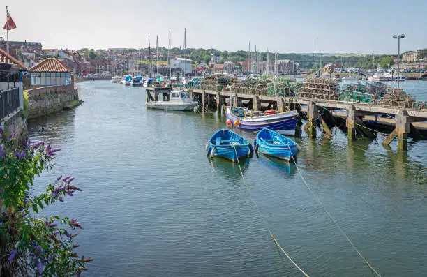 Photo of Jetty with boats and lobster pots.