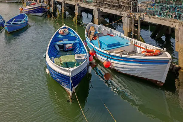 Photo of Jetty with boats and lobster pots.