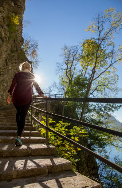 istock Woman walks up staircase in the mountains and sunlight 1165365821