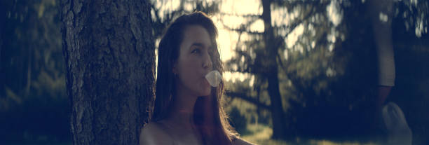 bonita chica con un chicle. día de verano en el parque - chewing gum women bubble blowing fotografías e imágenes de stock