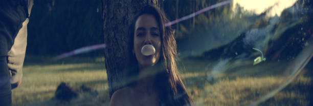 bonita chica con un chicle. día de verano en el parque - chewing gum women bubble blowing fotografías e imágenes de stock