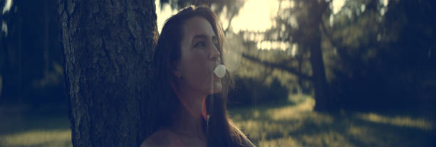 bonita chica con un chicle. día de verano en el parque - chewing gum women bubble blowing fotografías e imágenes de stock