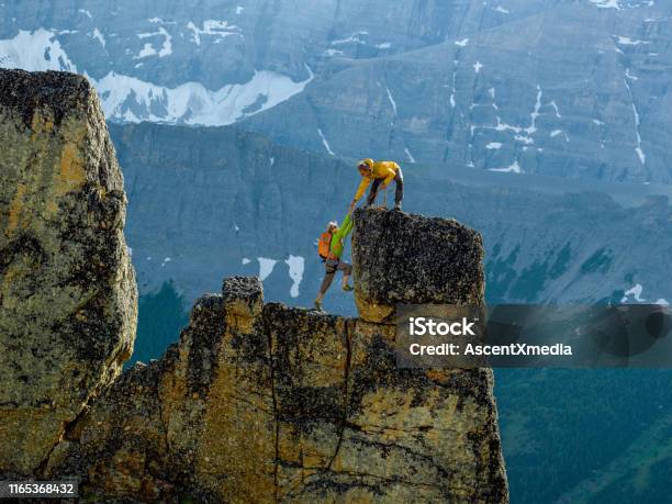 Mountaineers Scale Rocks Steps On Cliff With Rope Stock Photo - Download Image Now - Mountain, Support, A Helping Hand