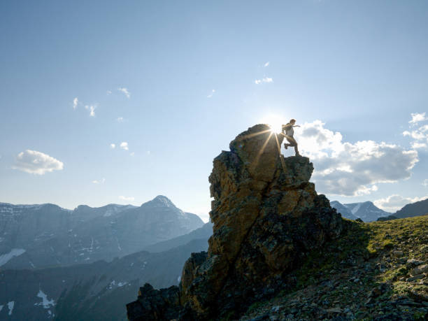 Businessman jumps down cliff steps in sunlight The wind is blowing his suit coat and he is backlit against the sun and sky air jump stock pictures, royalty-free photos & images