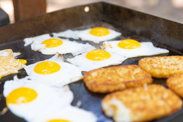 istock Hot breakfast cooking on outdoor flat grill while camping 1165370122