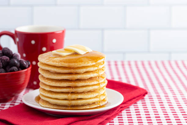 stack of freshly made pancakes on a gingham tablecloth - pancake buttermilk buttermilk pancakes equipment imagens e fotografias de stock