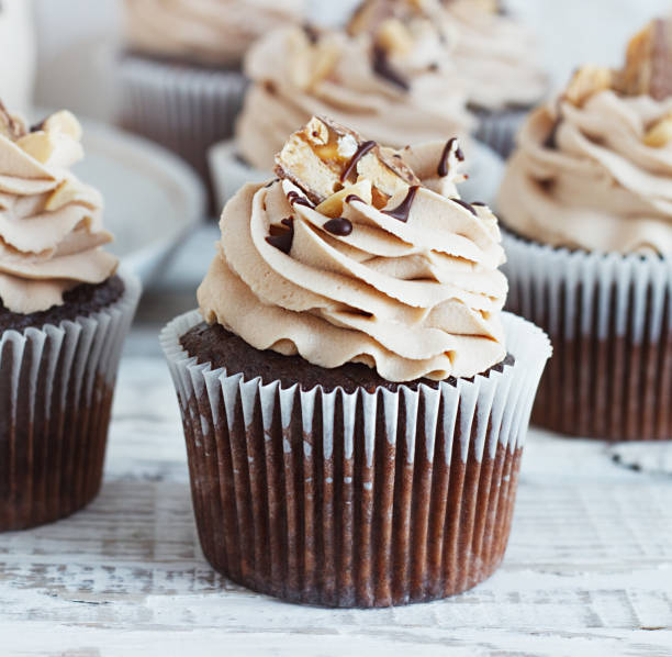 istock Chocolate cupcake with mousse cream icing on grunge white wooden background copy space 1165371302