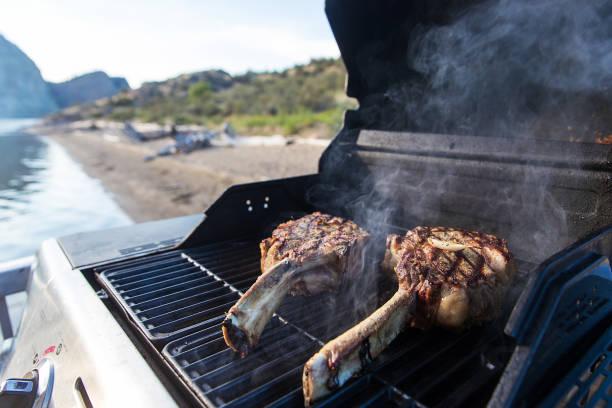 hand of the cook with the latex blue glove turning the grilled meat