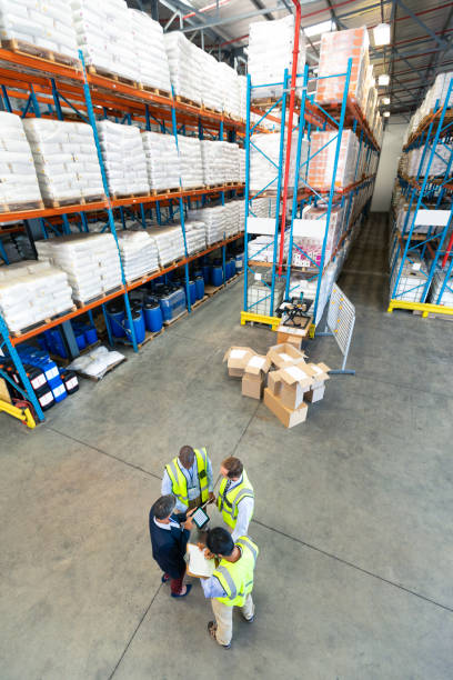 istock Warehouse staff discussing over digital tablet in warehouse 1165379503