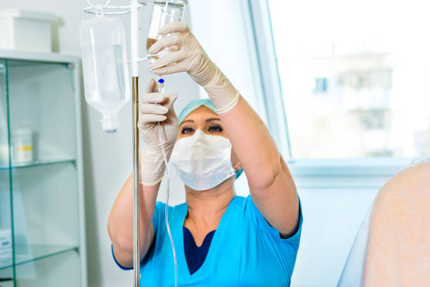 Set up the installed drip system. The medical worker adjusts the dropper to stimulate the patient infused stock pictures, royalty-free photos & images