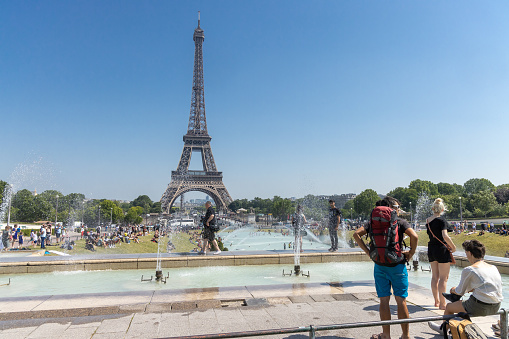 Paris, France, June 27, 2019: tourists and local taking a bath in the Jardins du Trocad ro Guardians of the Trocadero under the powerful water cannons