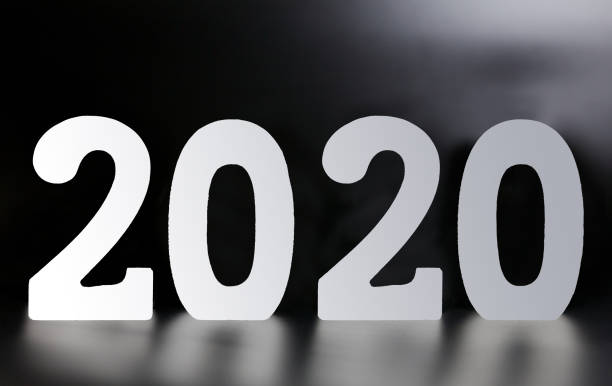 istock Year 2020 made from wooden white numbers on a black background 1165388216