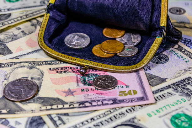 istock Old wallet with american cent coins over the dollar banknotes 1165390016