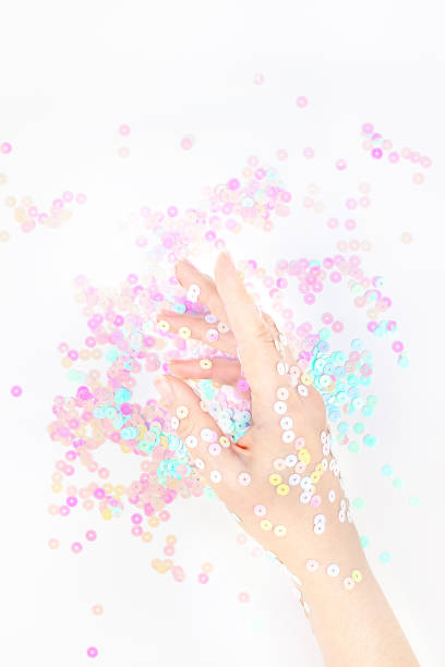 istock Pearl pastel confetti sparkles with woman hand 1165390271