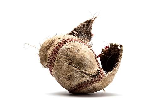 a baseball that has been destroyed and the cover shredding
