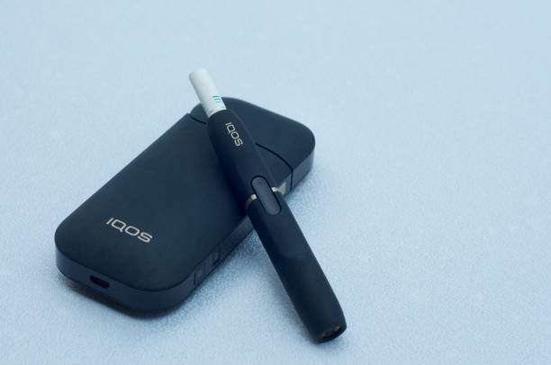 IQOS electronic cigarette with heat-not-burn system Caslano, Ticino, Switzerland - 26th July 2019 : Picture of IQOS a new heat-not-burn tobacco product technology produced by Philip Morris International in Neuchatel, Switzerland iqos e cig stock pictures, royalty-free photos & images