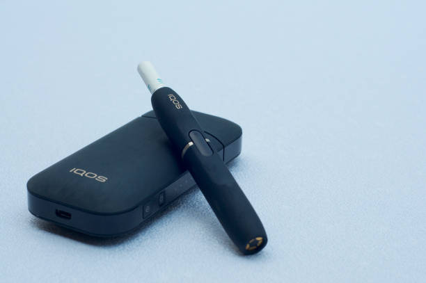 IQOS electronic cigarette with heat-not-burn system Caslano, Ticino, Switzerland - 26th July 2019 : Picture of IQOS a new heat-not-burn tobacco product technology produced by Philip Morris International in Neuchatel, Switzerland iqos e cig stock pictures, royalty-free photos & images
