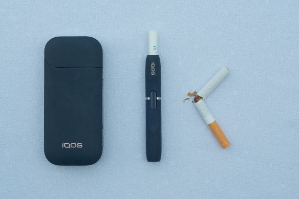 IQOS electronic cigarette with heat-not-burn system Caslano, Ticino, Switzerland - 26th July 2019 : Picture of IQOS a new heat-not-burn tobacco product technology produced by Philip Morris International in Neuchatel, Switzerland iqos e cig stock pictures, royalty-free photos & images