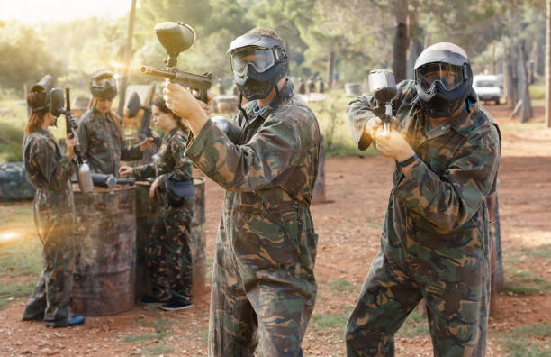 istock Cheerful men in camouflage holding guns ready for playing paintb 1165393014