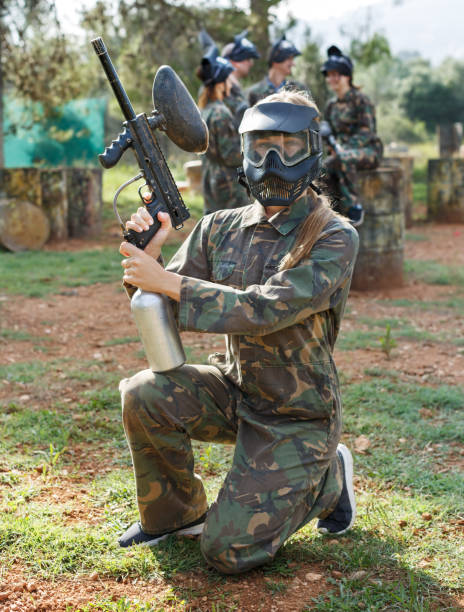istock Female paintball player with marker gun 1165393031