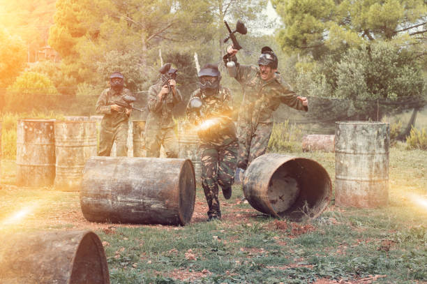 istock Paintball players aiming and shooting with guns 1165393044