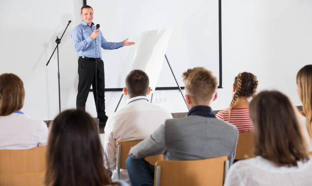 istock Male professor delivering speech to students 1165393230