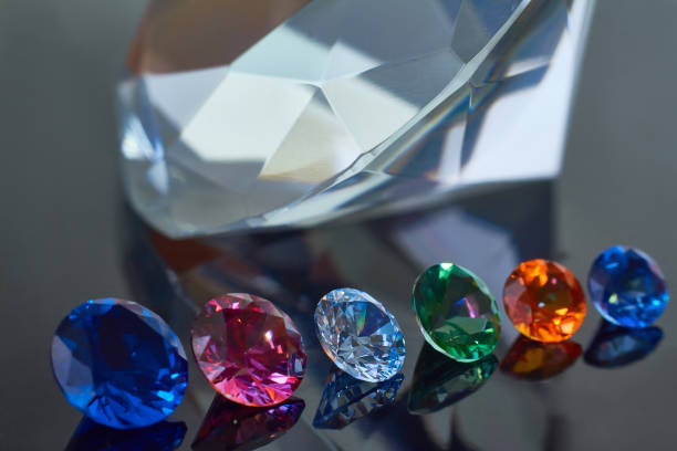 istock Huge diamond and several chic crystals on a deep black mirror surface, shimmer and sparkle 1165393290