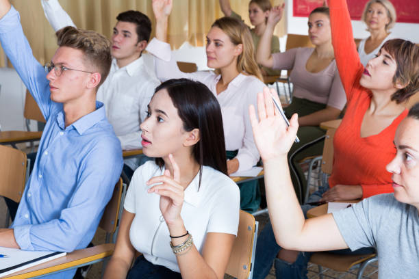 istock People in classroom raising hands to answer 1165394654