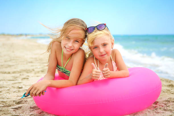 istock Happy girls lying on pink inflatable circle. 1165397141