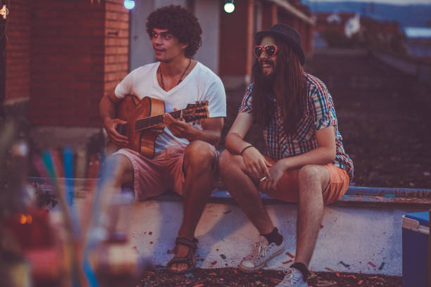 istock Two young musicians sitting at wall 1165399729