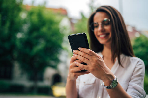 istock Young cheerful woman using smart phone, focus on hands. 1165399792