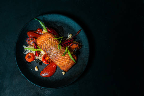 Delicious meal on a black plate, top view, copy space. Delicious meal on a black plate, top view, copy space. salmon seafood stock pictures, royalty-free photos & images
