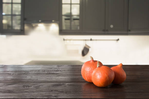 Ripe pumpkin on wooden tabletop in modern kitchen. Space for design. Thanksgiving day.