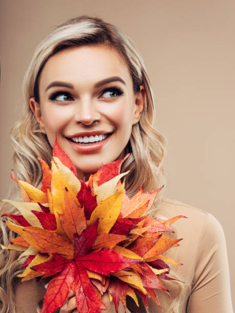 istock Beautiful girl with autumn leaf 1165402162
